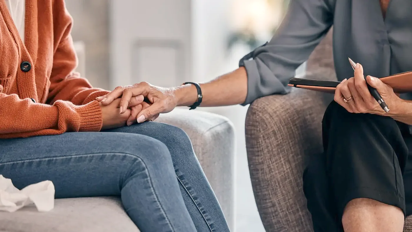 Clinician offering a reassuring hand during a consultation
